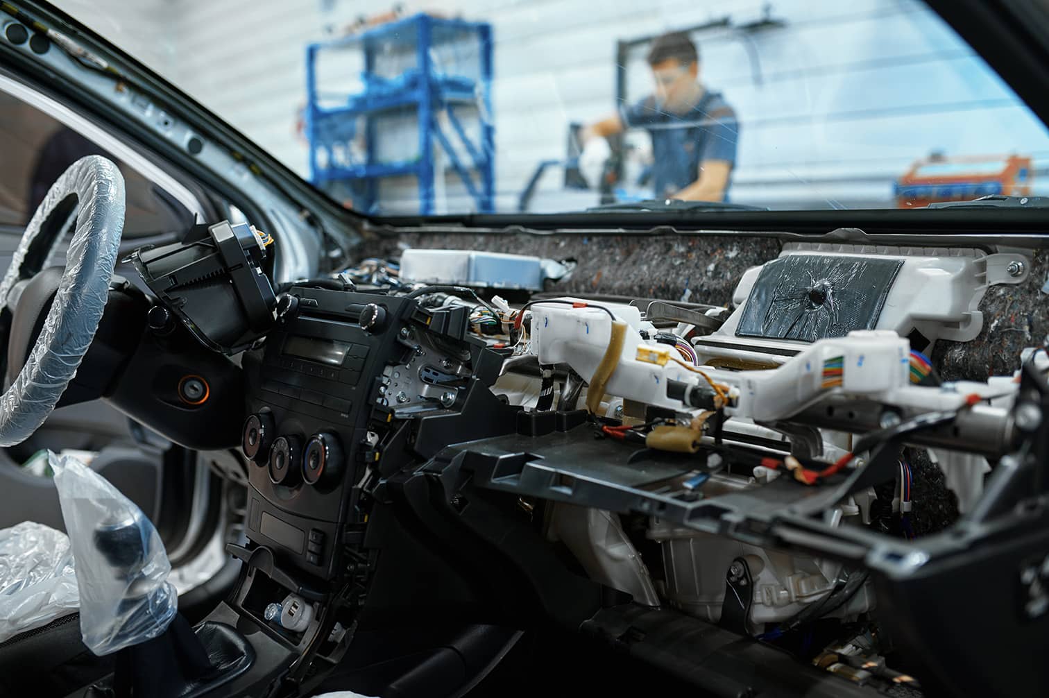 An interior of a car being built, showing parts of the wiring assembly under the dashboard.