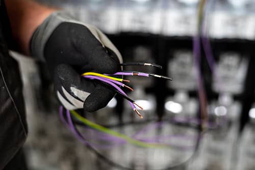 A worker holding some stripped wires